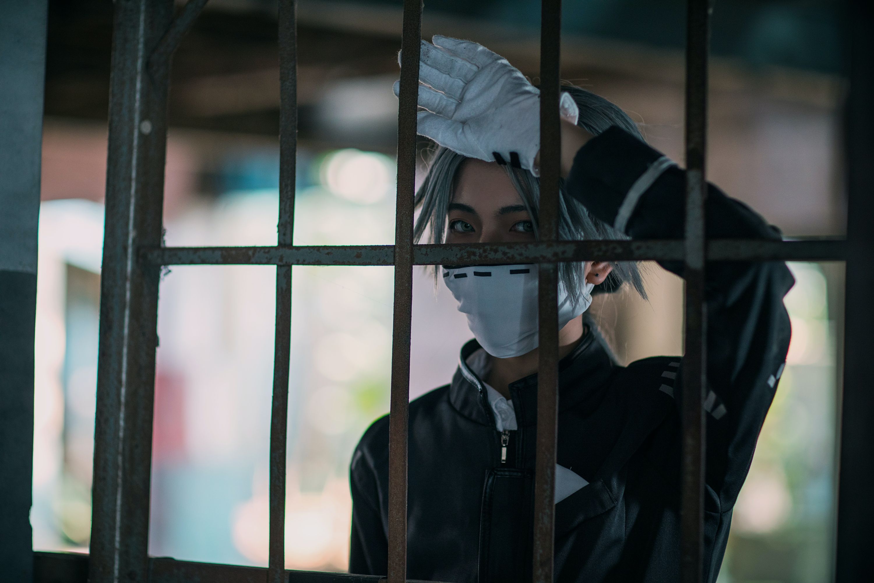Man behind bars wearing mask