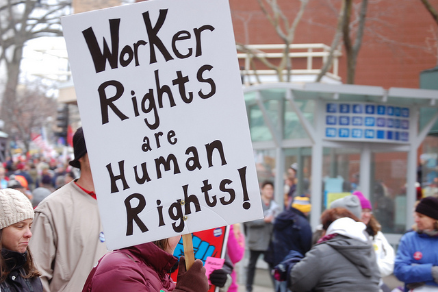 Protester holding sign saying "Worker's Rights Are Human Rights."
