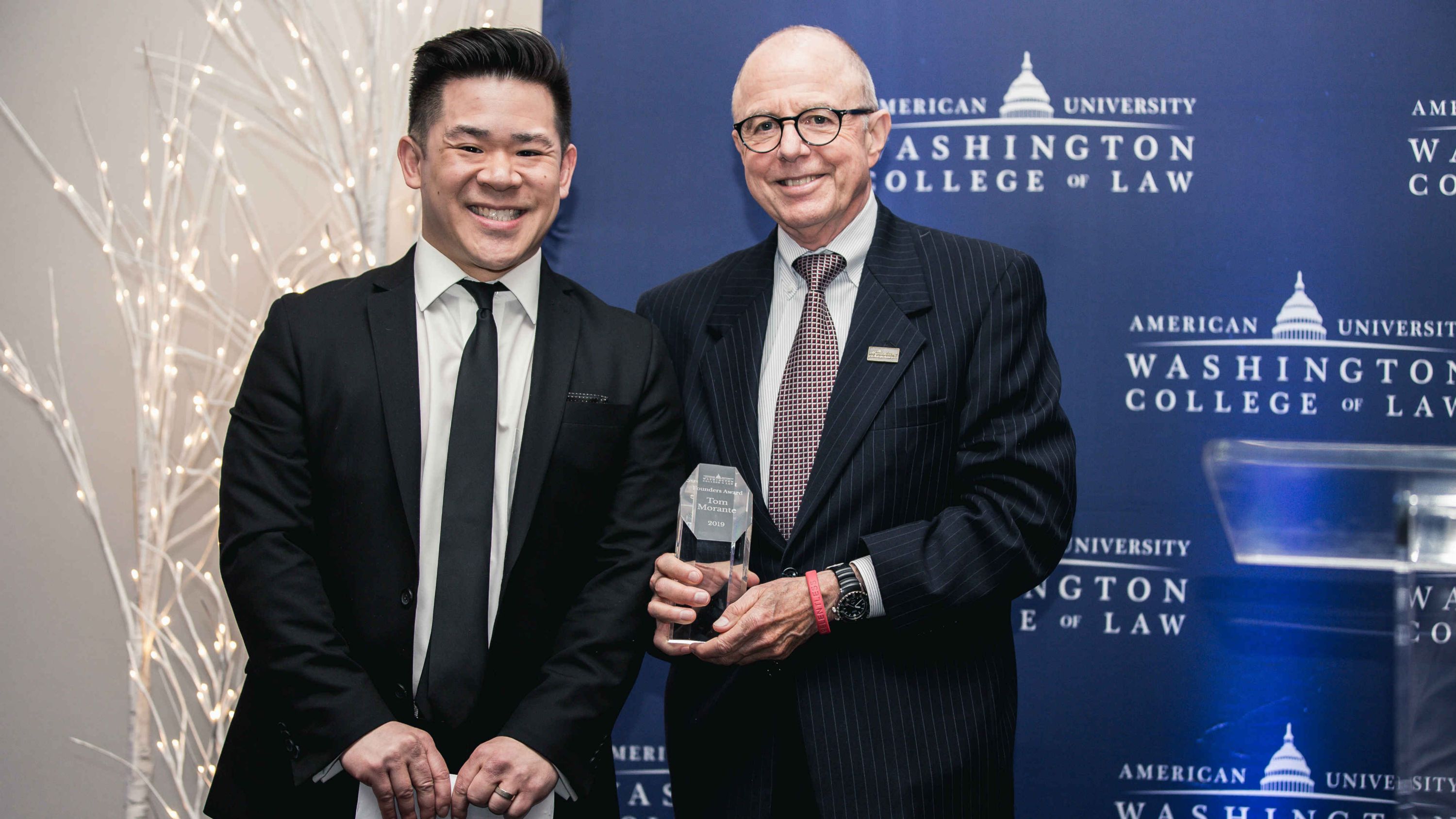 Myers Society Chair Tom Morante ’77 is presented with the Founders Award by incoming Myers Society Chair Eric Huang ’05.