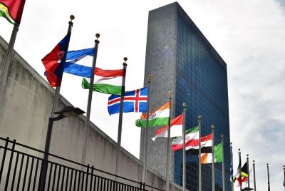 picture looking up at UN building with flags of different countries in front
