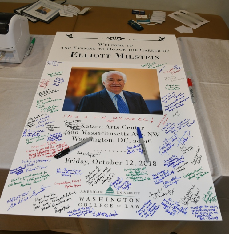 Celebration attendees sign a card for Professor Milstein.