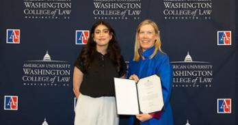 Leena Alsayab receiving the Clinical Program Dean's Award for Professional Responsibility from Interim Dean Heather Hughes.