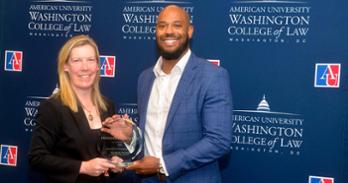 Professor Charles Ross receiving the 2026 Innovation in Pedagogy Award from Interim Dean Heather Hughes.
